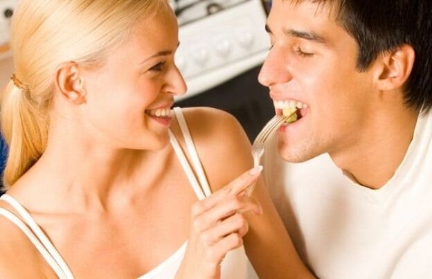 A girl feeds a guy products to increase potency.